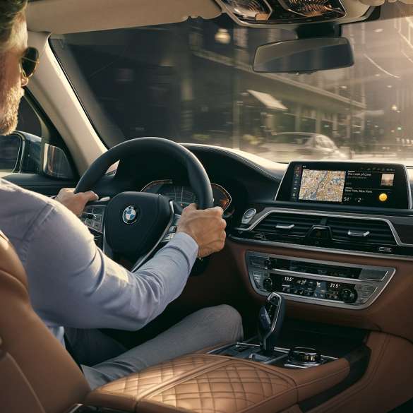 Elementos de Conectividad del BMW Serie 7 Sedán BMW Serie 7 Sedán: un hombre se sienta en el BMW y usa los elementos de Conectividad