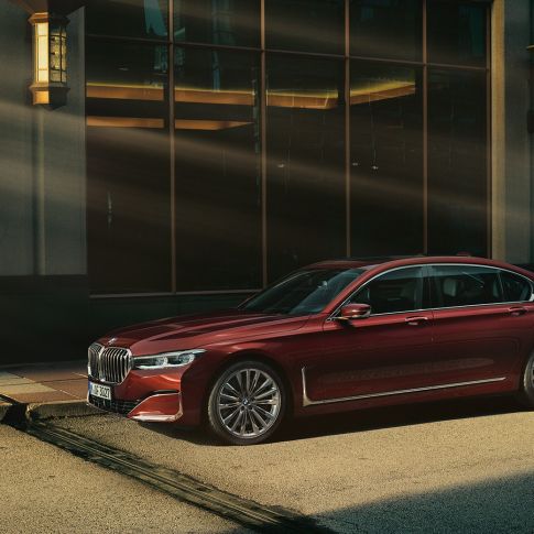 BMW Serie 7 Sedán Individual, vista lateral BMW Serie 7 Sedán Individual en vista lateral frente a un escenario urbano
