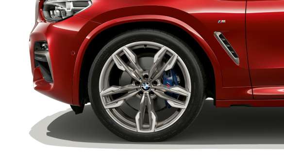Arco de llanta BMW X4. Vista lateral de los rines de aleación ligera y del paso de rueda del BMW X4 M40i 2018 Flamenco Red efecto brillante