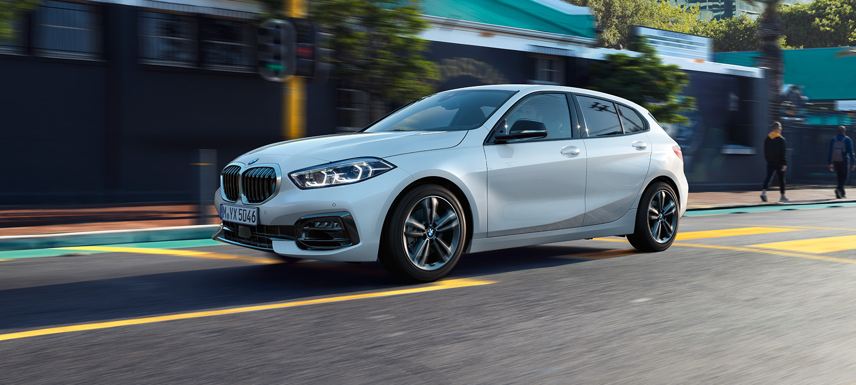 BMW Serie 1 Modelo Sport Line, vista lateral tres cuartos. BMW Serie 1 Modelo Sport Line en Mineral White metálico, vista lateral tres cuartos, conduciendo.