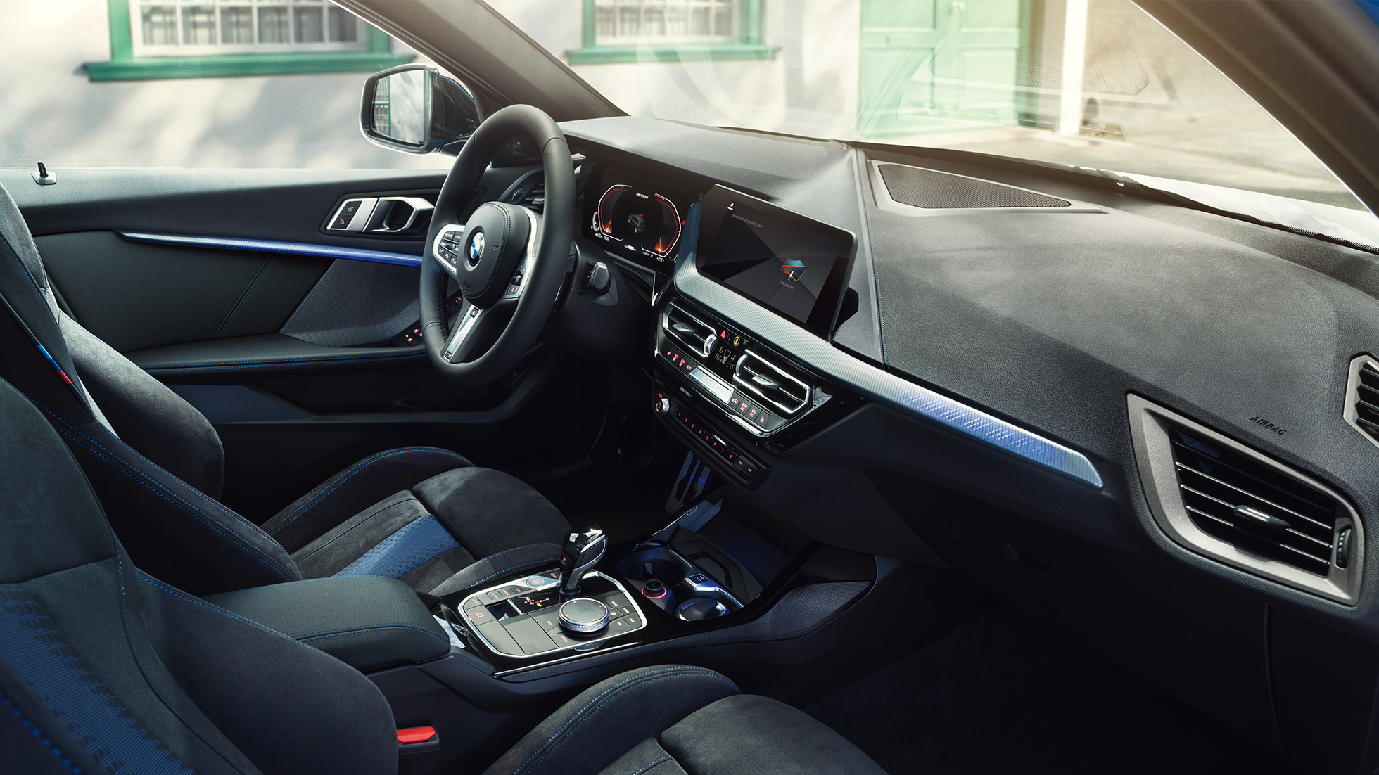 Interior deportivo del BMW Serie 1. Cabina del BMW Serie 1 con asientos M Sport, volante de cuero M y acabados interiores iluminados en vestiduras.
