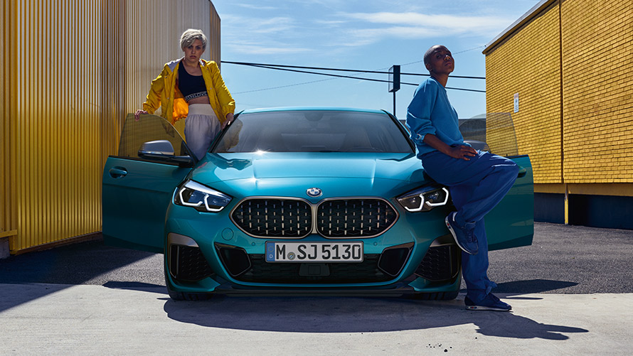 BMW Serie 2 Gran Coupé F44, vista del frontal BMW Serie 2 Gran Coupé F44 Snapper Rocks Blue metalizado, vista del frontal con las puertas abiertas y dos personas en el vehículo