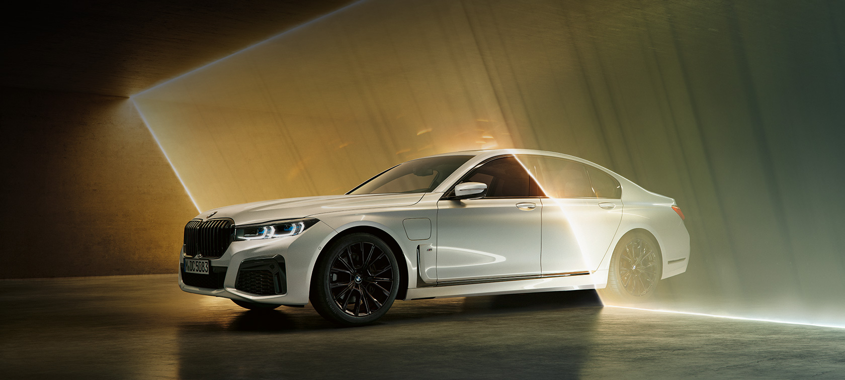 BMW Serie 7 Sedán, blanco, vista frontal de tres cuartos BMW Serie 7 Sedán: BMW blanco en vista frontal de tres cuartos rodeada de haces de luz