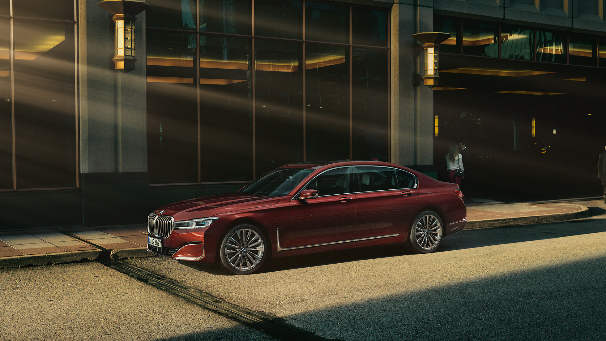 BMW Serie 7 Sedán Individual, vista lateral BMW Serie 7 Sedán Individual en vista lateral frente a un escenario urbano