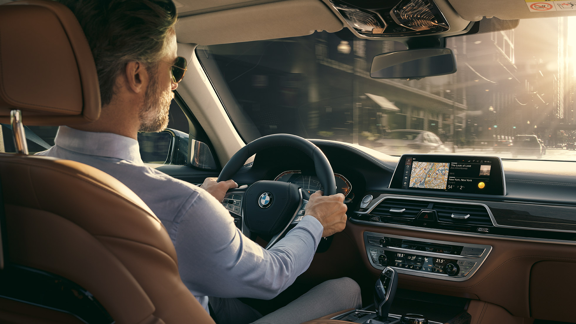 Elementos de Conectividad del BMW Serie 7 Sedán BMW Serie 7 Sedán: un hombre se sienta en el BMW y usa los elementos de Conectividad