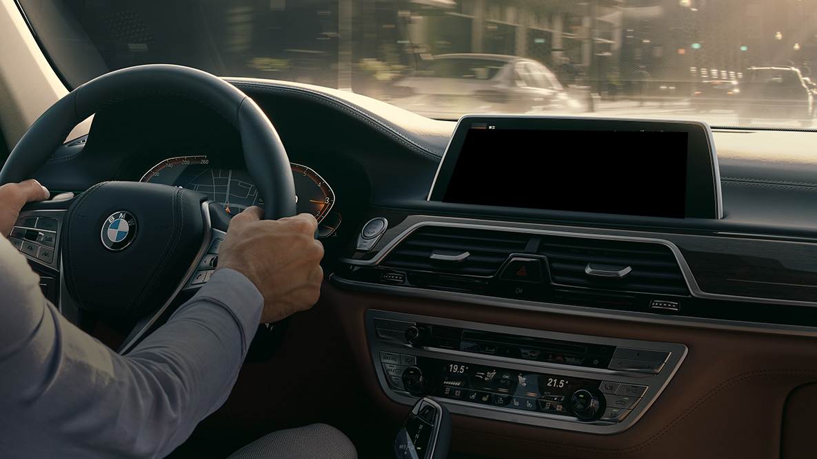 Asistente Personal Inteligente de BMW Asistente Personal Inteligente de BMW: un hombre conduce un BMW, acercamiento del Live Cockpit Professional