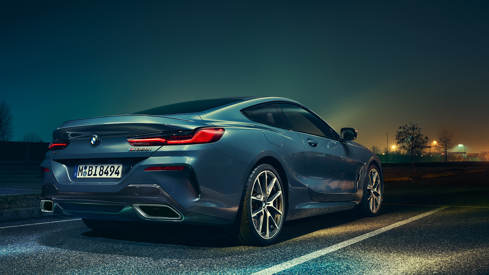 BMW Serie 8 Coupé, vista trasera de tres cuartos. BMW Serie 8 Coupé, vista trasera de tres cuartos, detenido frente a un escenario nocturno.