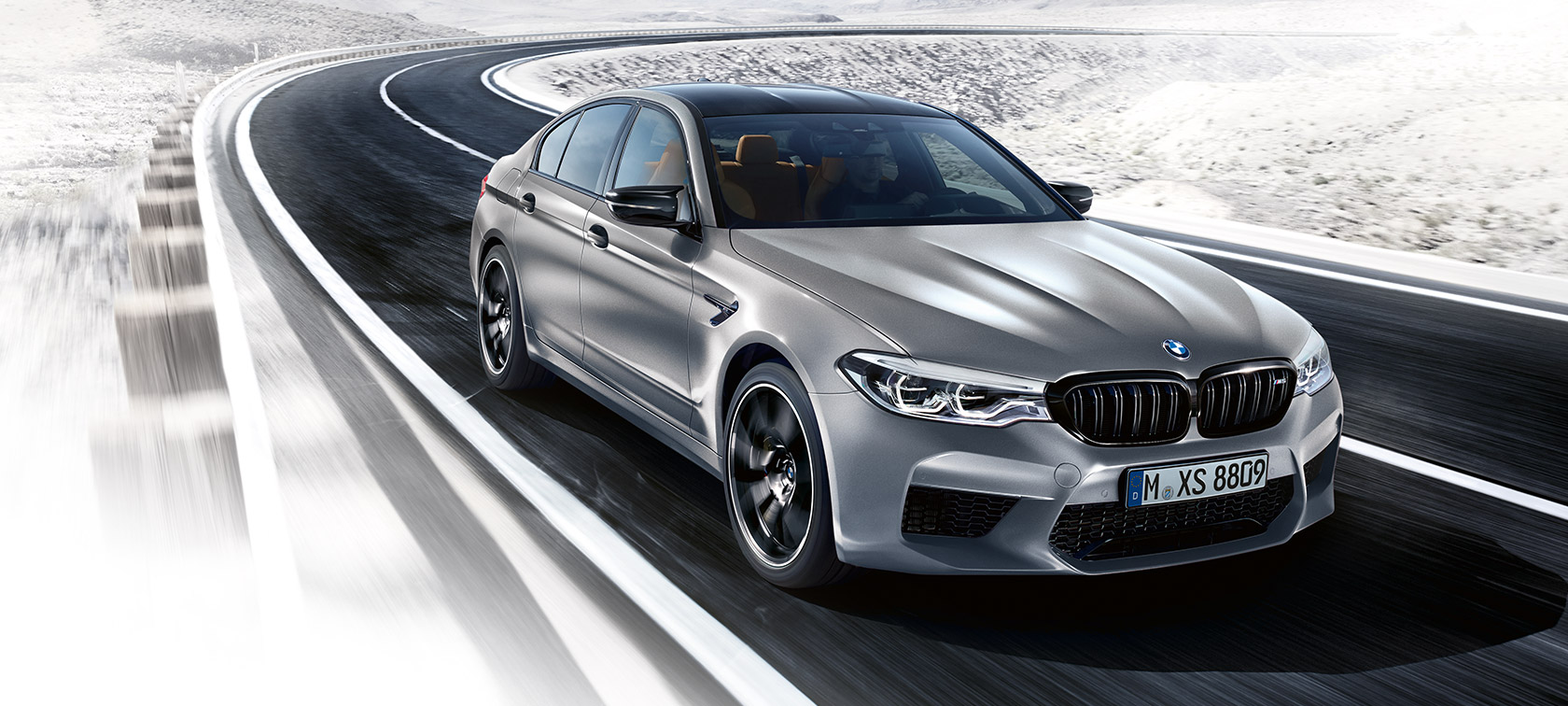 Toma frontal de tres cuartos en movimiento del BMW M5 Competition.