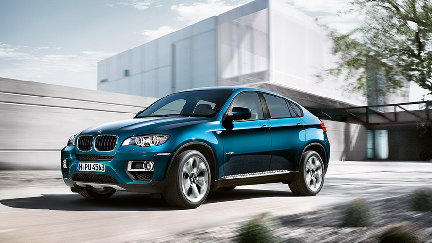 BMW X6 E71, primera generación, vista de tres cuartos del lateral, parado delante de un edificio Modelos BMW X BMW X6 E71, primera generación, vista de tres cuartos del lateral, parado delante de un edificio