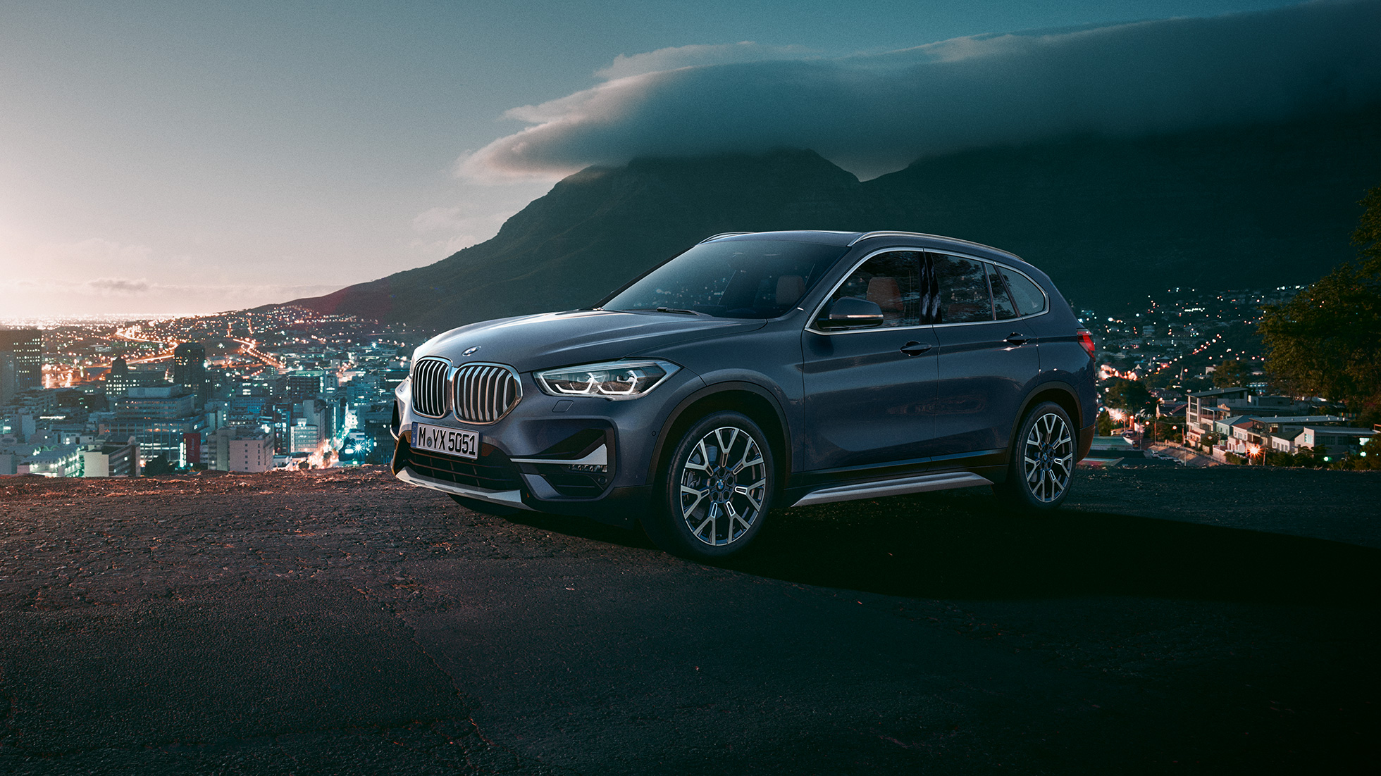 BMW X1, vista lateral tres cuartos. BMW X1, vista lateral tres cuartos frente a un escenario urbano.