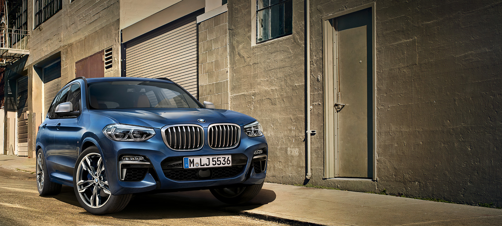 BMW X3 M40i, toma en frente de la pared de una casa BMW X3 M40i, toma en frente de la pared de una casa