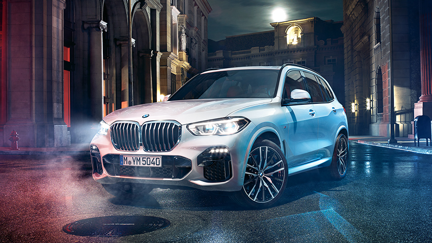 Imagen del frontal del BMW X5 de noche en un entorno urbano