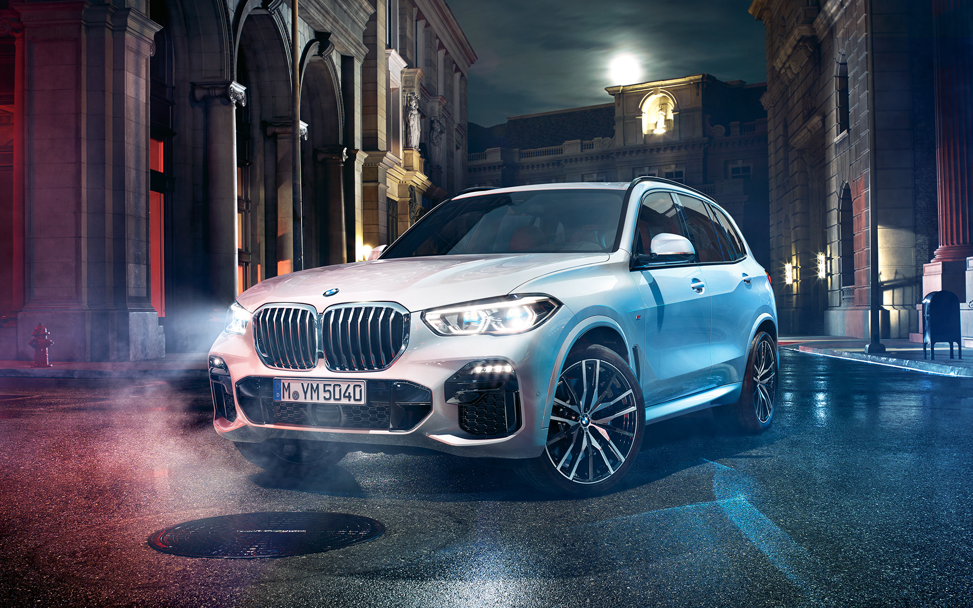 Imagen del frontal del BMW X5 de noche en un entorno urbano