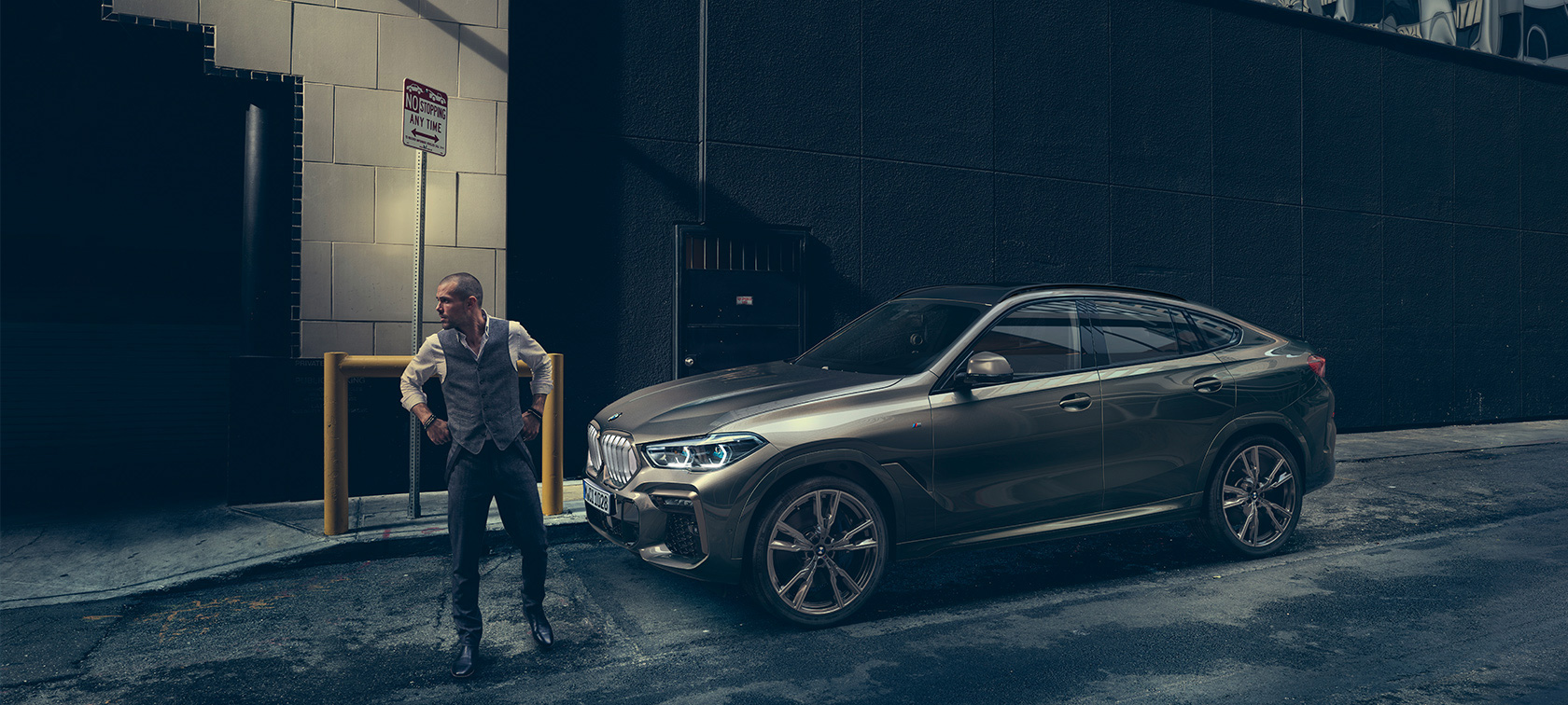 BMW X6 en perspectiva lateral frente a un escenario urbano.
