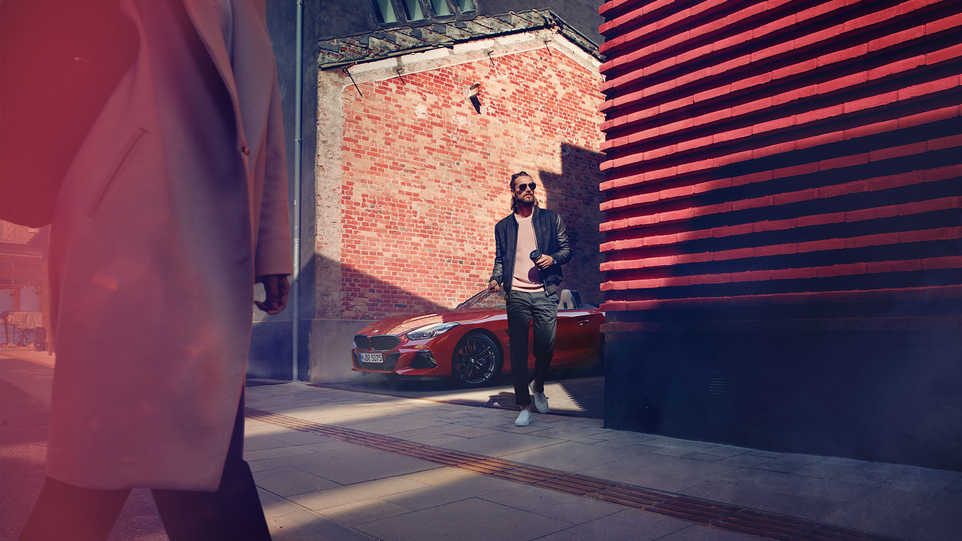 BMW Z4 Roadster en calles secundarias Hombre en calle secundaria frente al BMW Z4 Roadster
