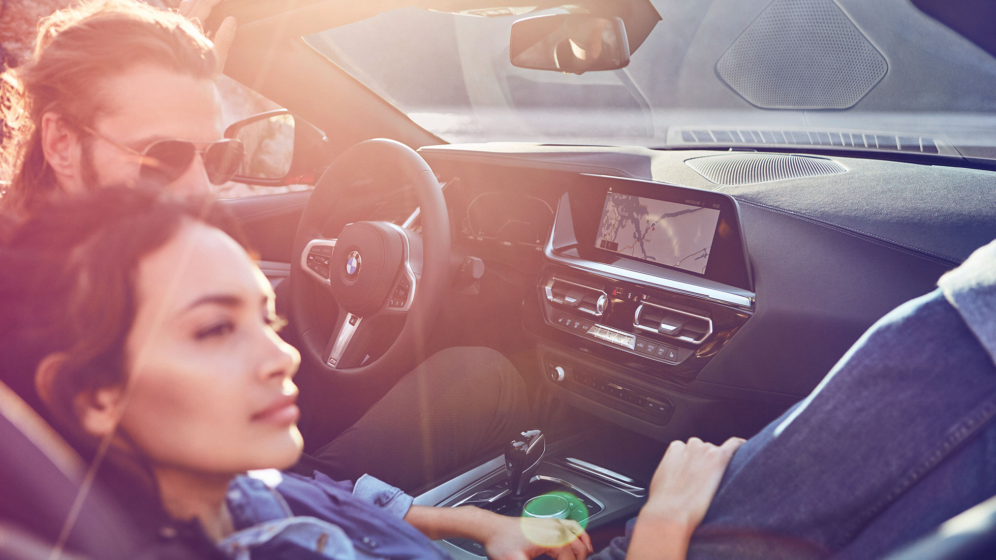 Mujer y hombre en el BMW Z4 Roadster Mujer de cabello oscuro y hombre en el BMW Z4 Roadster