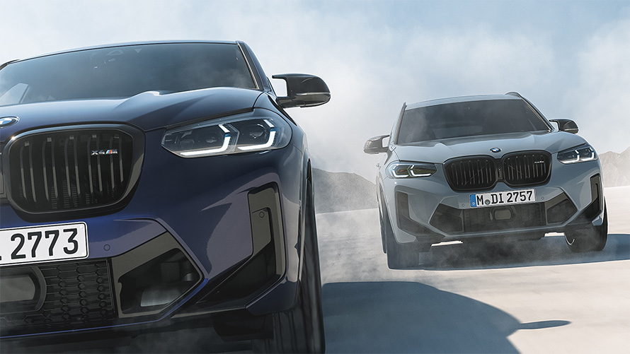 BMW X4 M F98 en BMW Individual Velvetblue, BMW X3 M F97 en BMW Individual Nardogrey, vista del frontal, en marcha
