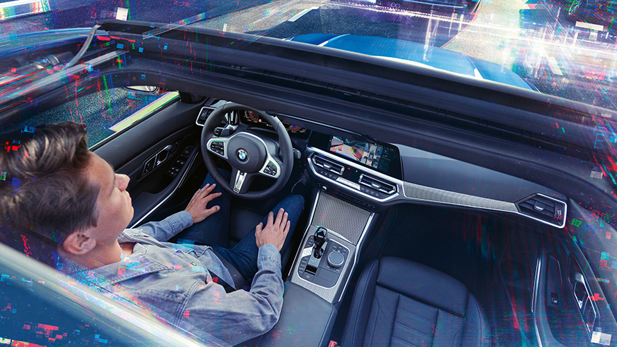 BMW Personal CoPilot: intelligent Parking Man is sitting in a parking BMW using the BMW Personal CoPilot parking assistant.