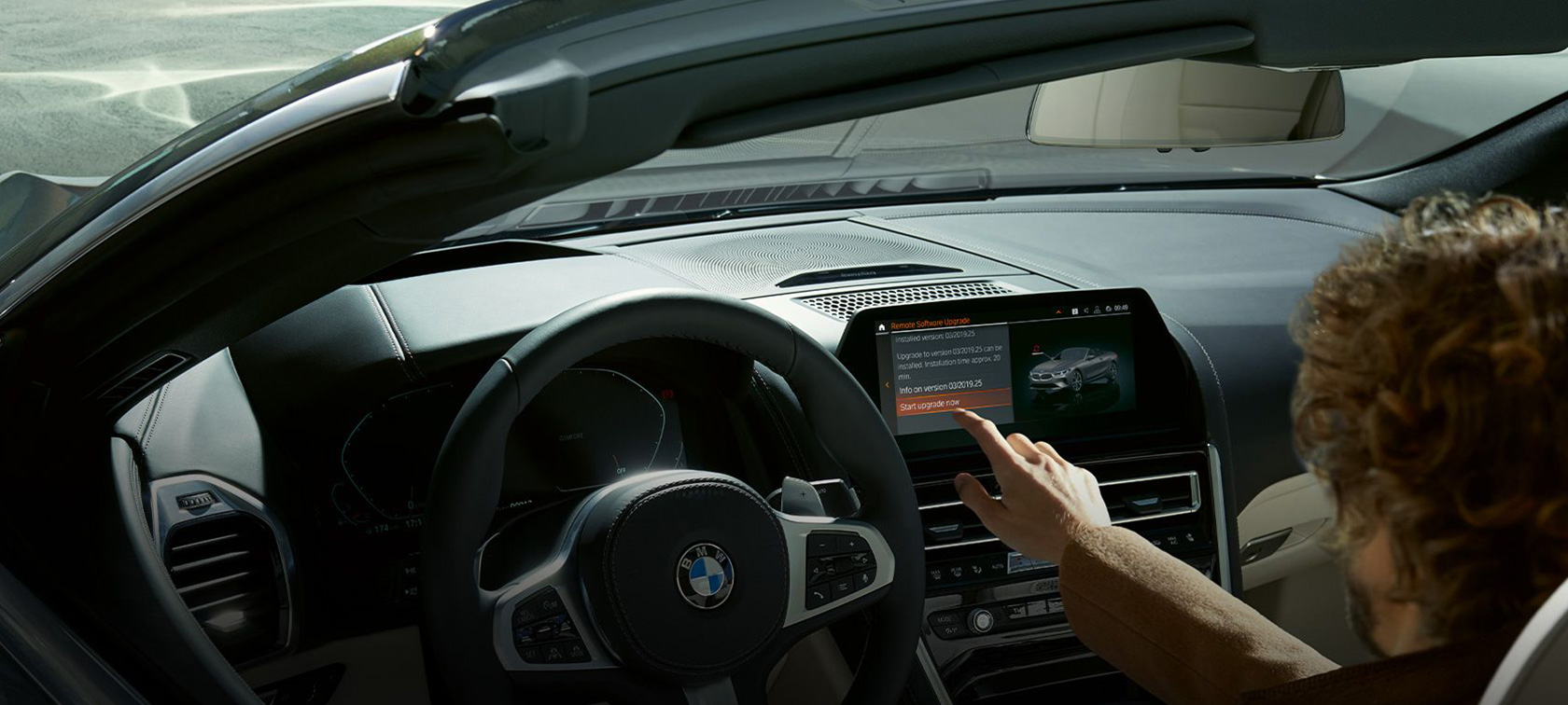 BMW Remote Software Upgrade Un hombre se sienta en un BMW e inicia BMW Remote Software Upgrade